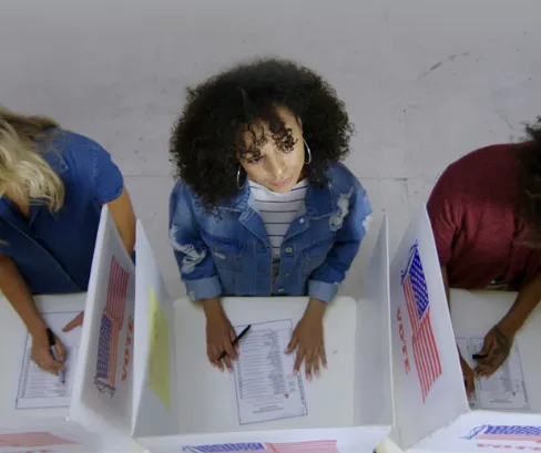 Picture of three people voting.