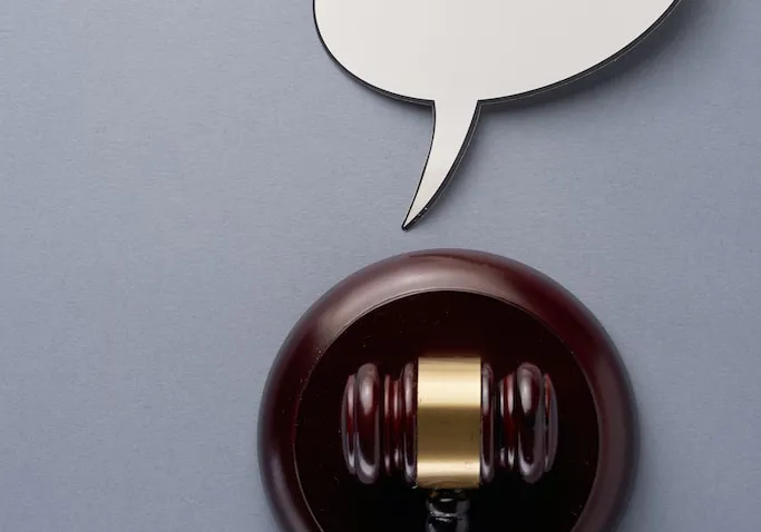 Picture of a gavel in a grey background. 